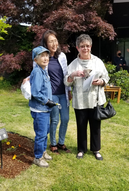 Three women standing to the side of the tree